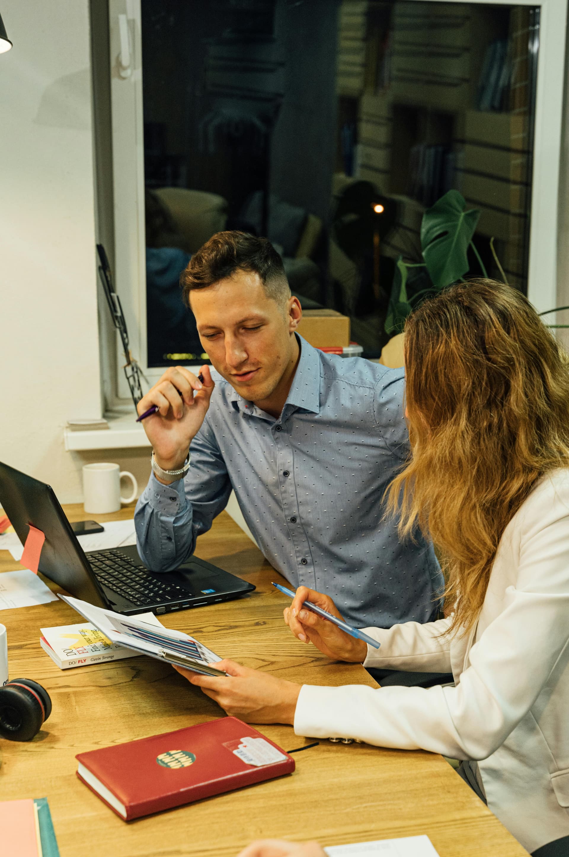 Two colleagues collaborating over a laptop.