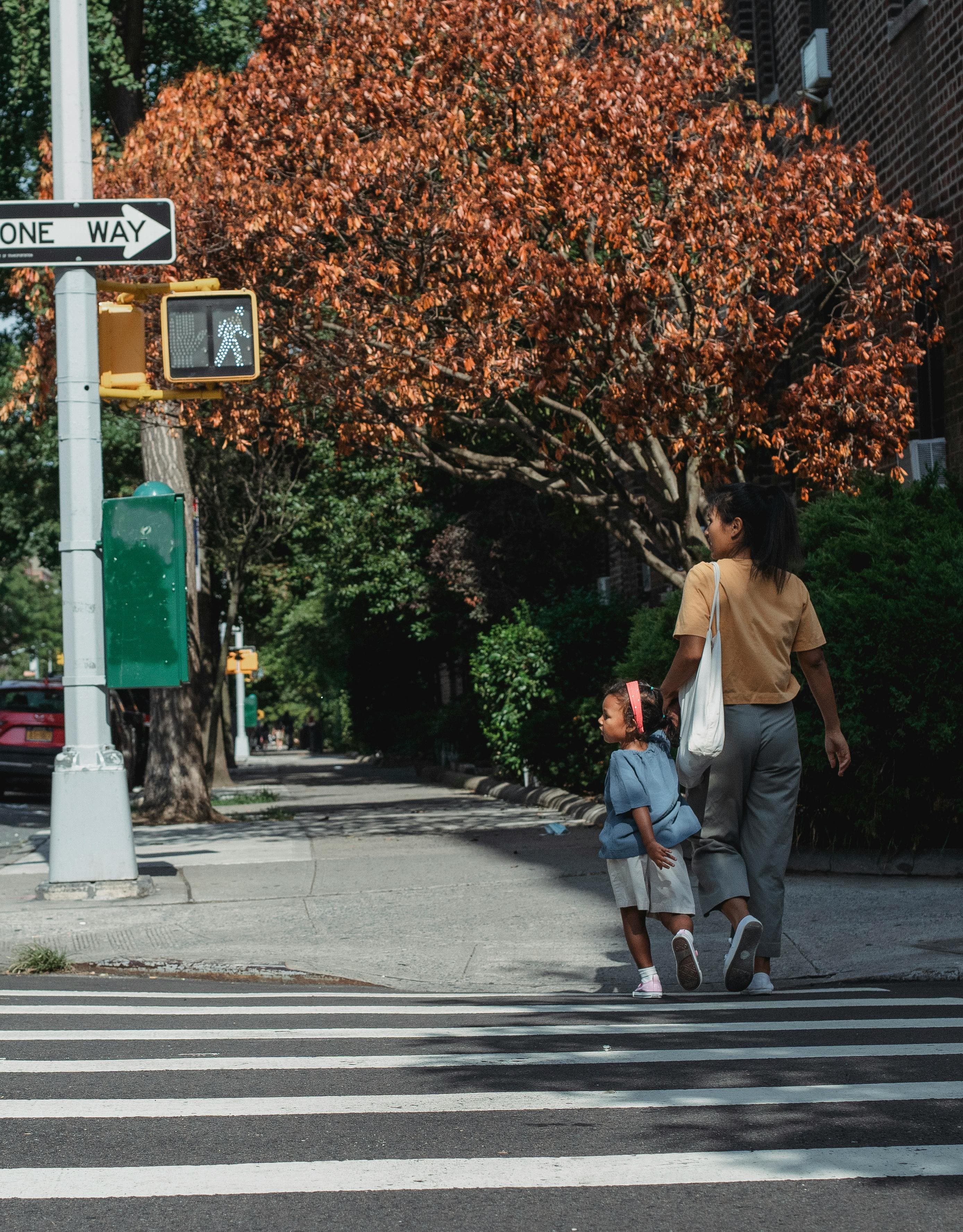A person crossing a busy city street, representing the practical realities of relocation.
